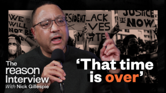 A picture of John McWhorter against a backdrop of protesters holding cardboard signs. The Reason Interview logo is in the bottom left corner and the words "that time is over" are in white and orange | Illustration: Lex Villena