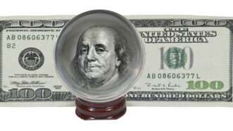 A U.S. $100 bill, with the picture of Benjamin Franklin magnified by a crystall ball. | Penywise | Dreamstime.com