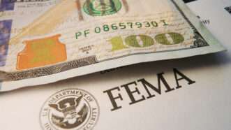 A $100 bill next to FEMA-branded documents | ID 345760493 © Zimmytws | Dreamstime.com