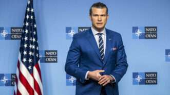 U.S. Defense Secretary Pete Hegseth stands before a backdrop with the NATO logo, and an American flag. | Wiktor Dabkowski/ZUMAPRESS/Newscom