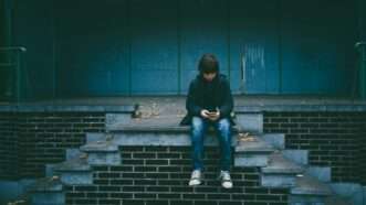 Child sitting outside on a smartphone | Photo by <a href="https://unsplash.com/@gaellemarcel?utm_content=creditCopyText&utm_medium=referral&utm_source=unsplash">Gaelle Marcel</a> on <a href="https://unsplash.com/photos/boy-sitting-on-concrete-stairs-FLdK5N-YGf4?utm_content=creditCopyText&utm_medium=referral&utm_source=unsplash">Unsplash</a>       