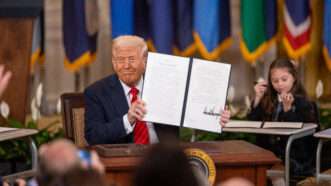 President Trump holding up an executive order | Hu Yousong / Xinhua News Agency/Newscom