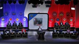The stage for the 2017 NBA Draft Lottery, with podiums and representatives for each team in the lottery, and a wall behind them with their logos. | Charles Wenzelberg/NY Post/MEGA / Newscom/DBNYC/Newscom