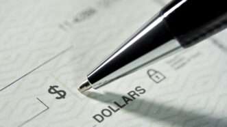 Close-up of a pen filling out a paper check. | Pictac | Dreamstime.com