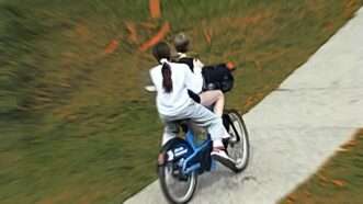 Two children riding on a bike. | Illustration: Eddie Marshall | Aspen Police Department