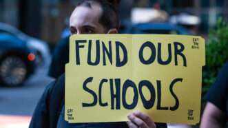Protestor holding a sign that reads, "FUND OUR SCHOOLS" | Gabriele Holtermann-Gorden/Sipa/Newscom