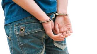 A young boy is handcuffed behind his back. | Alexander  Raths | Dreamstime.com