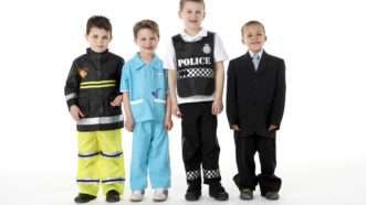 Four young children, dressed as a firefighter, a veterinarian, a police officer, and an executive in a business suit. | Monkey Business Images | Dreamstime.com