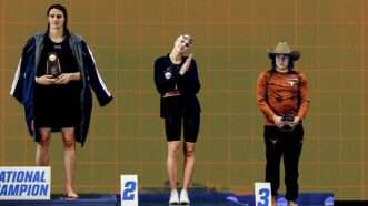 Lia Thomas (left) is seen on the podium next to second place finisher Emma Weyant and third place finisher Erica Sullivan after Thomas won the NCAA Division I championship title for the 500-yard freestyle. | Illustration: Eddie Marshall | Midjourney | Rich von Biberstein/Icon Sportswire DKB/Rich von Biberstein/Icon