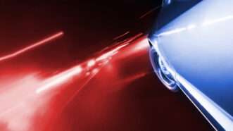 Close-up of a car with red lights in the background, signifying a police chase. | Donvictorio | Dreamstime.com