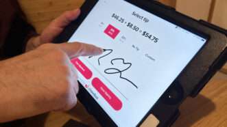 Customer using checkout system and choosing tip | Lindsey Nicholson/UCG/Universal Images Group/Newscom