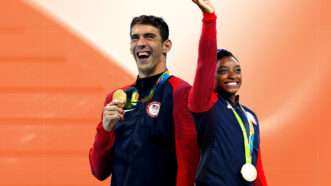 Against an orange background, Michael Phelps has a huge smile as he holds up his gold medal in his right hand,a nd Simone Biles waves with her right hand with a big smile as a gold medal hangs around her neck. | Illustration: Eddie Marshall | Agência Brasil | Fotografias | Fernando Frazão | Wikimedia Commons | Stockholm Paris Studio | Unsplash