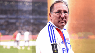 A man standing on a soccer field wearing an Olympique Lyonnais jersey turns to face the camera. | Illustration: Eddie Marshall |  Icon Sport/LECOEUR Philippe / Agence FEP/Sipa USA/Newscom