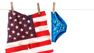 A pair of American flag swimming trunks pinned to a clothesline next to a pair of small European Union flag briefs | Illustration: Joanna Andreasson; Source images: iStock