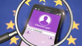 A magnifying glass over the screen of a cellphone displaying a generic Messenger app. | Kontakt5956 | Dreamstime.com