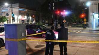 Two investigators with the Washington, D.C., Metropolitan Police Department stand behind yellow tape at the scene of a stabbing. | Kyle Mazza, Kyle Mazza/ZUMAPRESS/Newscom