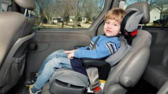A toddler sits in his car seat in the back of a car. | Suzanne Tucker | Dreamstime.com