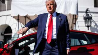 President Donald Trump stands next to a red Tesla Model S on the South Lawn of the White House. | CNP/AdMedia/SIPA/Newscom