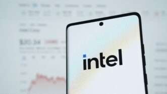 The intel logo is seen on a phone in front of a stock report | imageBROKER/Md Mamun Miah/Newscom