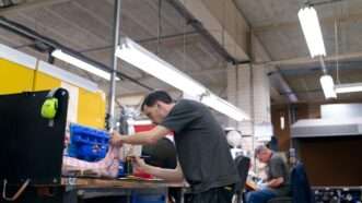 Workers in a manufacturing plant handle item components | Source: Unsplash 