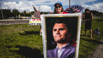 Woman holding Charlie Kirk poster | Dave Decker/ZUMAPRESS/Newscom