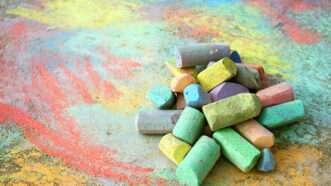 Sticks of sidewalk chalk piled up on the concrete. | Christinlola | Dreamstime.com