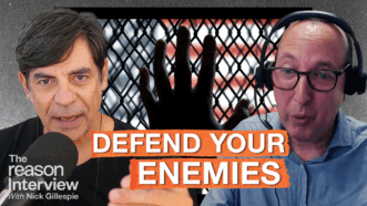 Nick Gillespie speaks into a microphone on the left, and ACLU legal director Ben Wizner appears on the right wearing headphones. Behind them is a dark fence with a hand pressed against it and a blurred American flag in the background. Bold orange text across the center reads “DEFEND YOUR ENEMIES.” | Illustration: Eddie Marshall