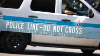 Chicago Police Department vehicle, with a wooden barrier that says "Police Line - Do Not Cross" in the foreground. | Roberto Galan | Dreamstime.com