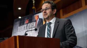 Sen. Brian Schatz speaks at a podium | BONNIE CASH/UPI/Newscom