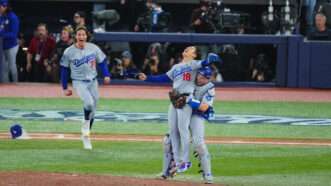 Dodgers players Yoshinobu Yamamoto and Will Smith embrace and shout after winning the World Series—Tyler Glasnow is in the background running toward them. | Yuji Arakawa/Full-Count/AFLO/Newscom
