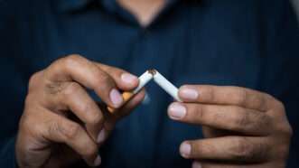 A man breaks a cigarette in half. | Nopphon Pattanasri | Dreamstime.com