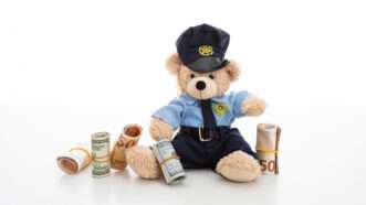 Policeman teddy bear surrounded by cash and coins. | Rawf88 | Dreamstime.com