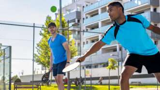 Two pickleball players outside on a sunny day. | ID 353614515 ©  Iván Las Heras | Dreamstime.com