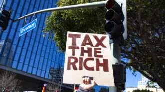 A protester holds a "Tax the Rich" sign in Los Angeles | Katrina Kochneva/ZUMA Press/Newscom