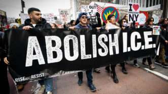 Protesters march with a black banner that reads "Abolish I.C.E." | Michael Brochstein/Sipa USA/Newscom