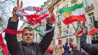 Protester holds tattered Iranian flag. | Erez Lichtfeld/SIPA/Newscom