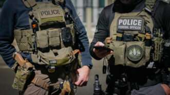 Two-federal-law-enforcement-officers-coordinate-with-other-officials-on-the-ground-during-an-enhanced-immigration-enforcement-operation-near-Washington-D.C.-Feb-scaled. | DHS.gov