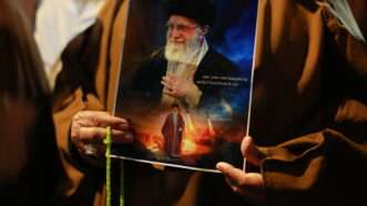 Iraqi Shiites shout slogans as they carry a portrait of Ayatollah Ali Khamenei and wave Iranian flags during a protest near the US embassy in Baghdad against recent US-Israeli strikes on Iran. Bagdad, Iraq. 28 February 2026. | Ameer Al-Mohammedawi/dpa/picture-alliance/Newscom