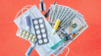 Medication and a mask are seen atop $100 bills | Envato