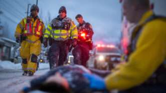 Paramedics approach someone on the ground in cold weather. | Midjourney