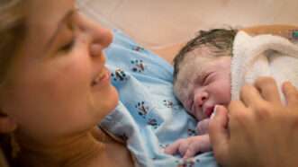 A mother holding her newborn child in a hospital | Vladi Samodarov/ Dreamstime