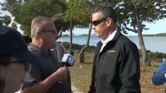 Local 10 News reporter Jeff Weinsier holds a microphone up to Miami-Dade Sheriff's Deputy Lester Aguilar. | WPLG Local 10 via YouTube