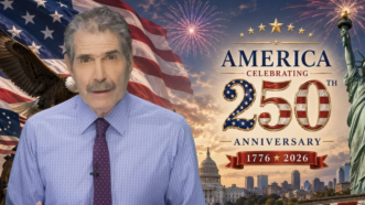 John Stossel stands next to an America 250 sign | Stossel TV