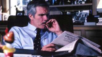 Ted Turner smoking a cigar and reading a newspaper | Robin Rayne/ZUMAPRESS/Newscom