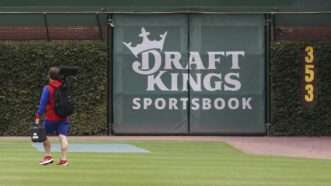A logo for "DraftKings Sportsbook" is pictured on the outfield wall of Wrigley Field, surrounded by ivy. | John J. Kim/TNS/Newscom