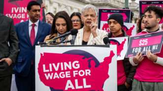 Politicians holding a press conference with a sign that says Living Wage for All | Sue Dorfman/ZUMAPRESS/Newscom