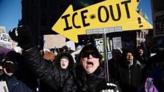 A protestor holding a sign that says "ICE OUT" | Photo: TED NIETERS/Polaris/Newscom