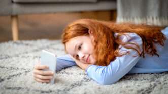 Teenager using a smartphone | DPST/Newscom