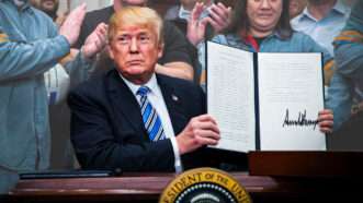 President Donald Trump holding up his aluminum tariff order | Michael Reynolds/dpa/picture-alliance/Newscom