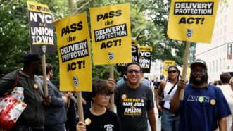 People hold signs in favor of New York City's Delivery Protection Act | IMAGO/ZUMA Press/Newscom